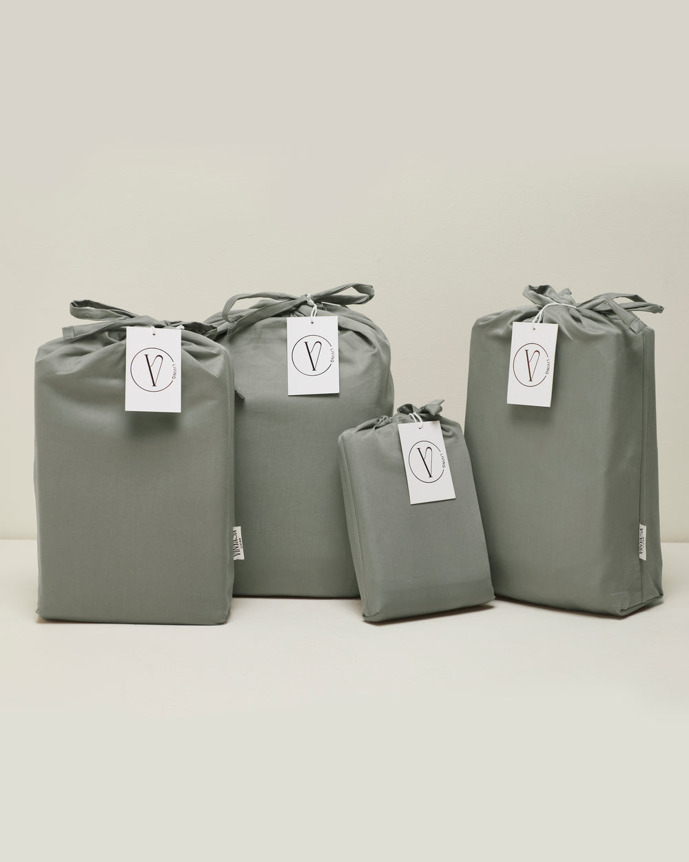 Sage green fabric storage bags with Vinyasa Living tags