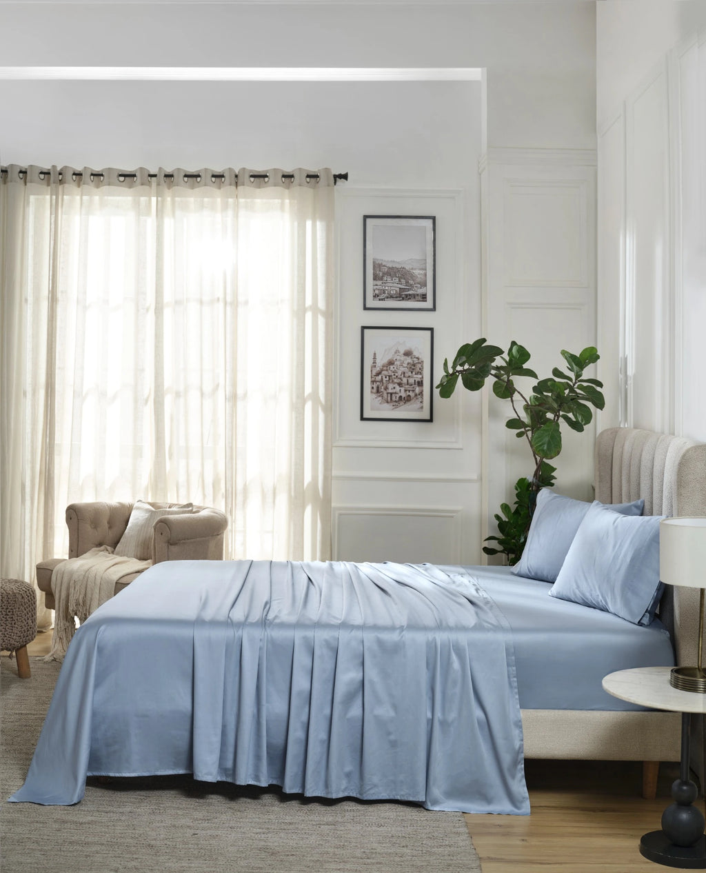 Dusty Blue 600TC sateen flat sheet set with standard pillow covers, side view on a made bed