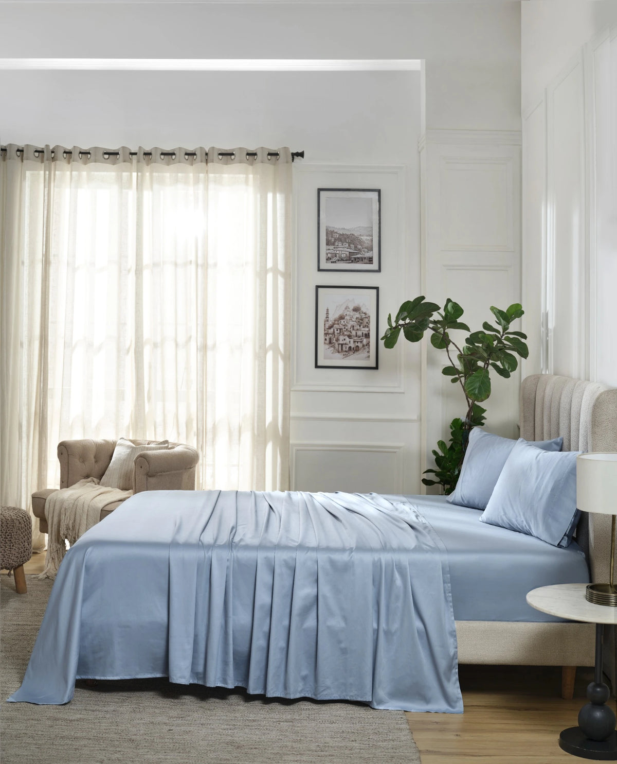 Dusty Blue 600TC sateen flat sheet set with standard pillow covers, side view on a made bed