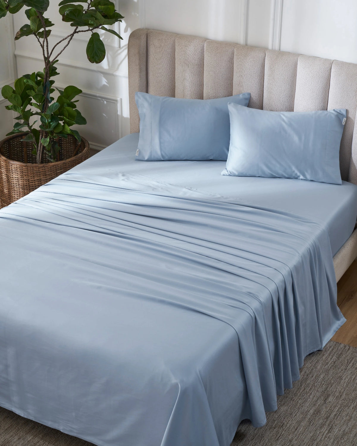Dusty Blue 600TC sateen flat sheet set with standard pillow covers, top view on a made bed