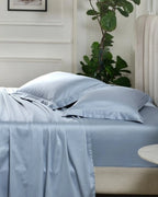 Dusty Blue 600TC sateen standard pillow cover set with flange, side view on a made bed