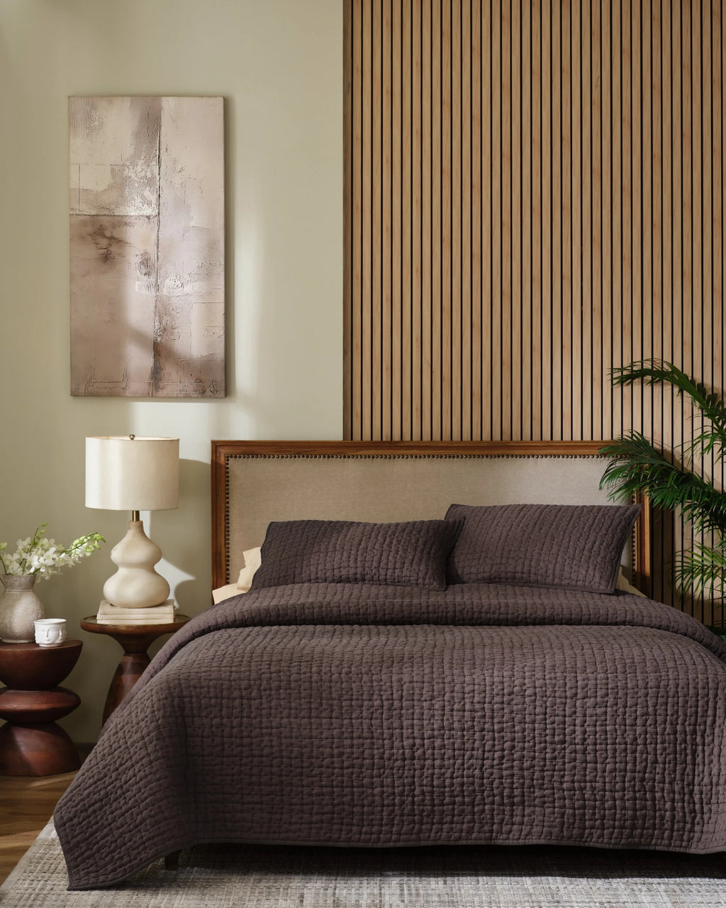 Espresso European linen box-stitch hand quilt set with standard pillow covers, front view on a made bed