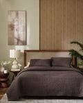 Espresso European linen box-stitch hand quilt set with standard pillow covers, front view on a made bed