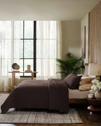 Espresso European linen box-stitch hand quilt set with standard pillow covers, side view on a made bed