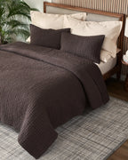 Espresso European linen box-stitch hand quilt set with standard pillow covers, top view on a made bed