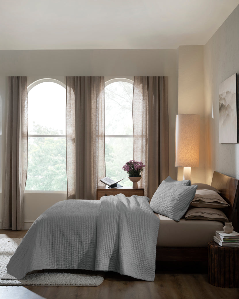 Grey habutai silk hand-quilted quilt set with king pillow covers, side view on a made bed