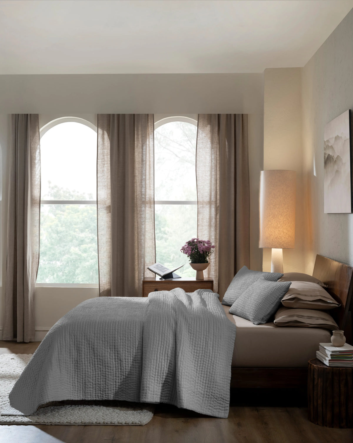 Grey habutai silk hand-quilted quilt set with standard pillow covers, side view on a made bed