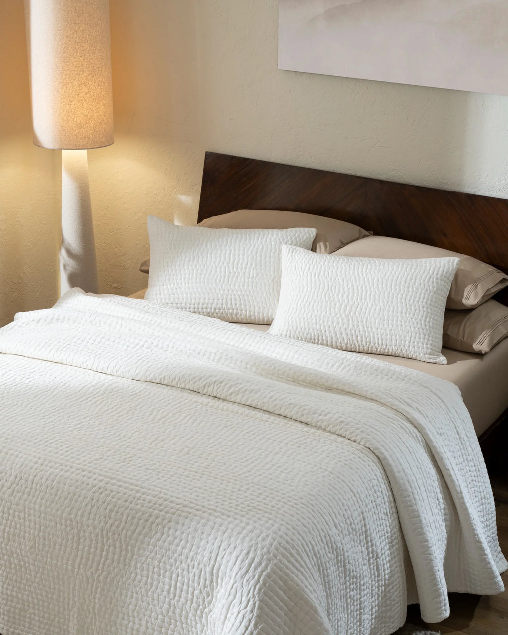 Ivory habutai silk hand-quilted quilt set with standard pillow covers, top view on a made bed