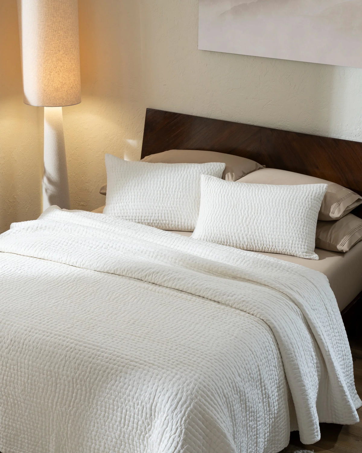 Ivory habutai silk hand-quilted quilt set with standard pillow covers, top view on a made bed