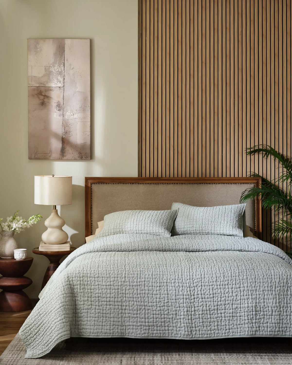 Mist European linen box-stitch hand quilt set with standard pillow covers, front view on a made bed
