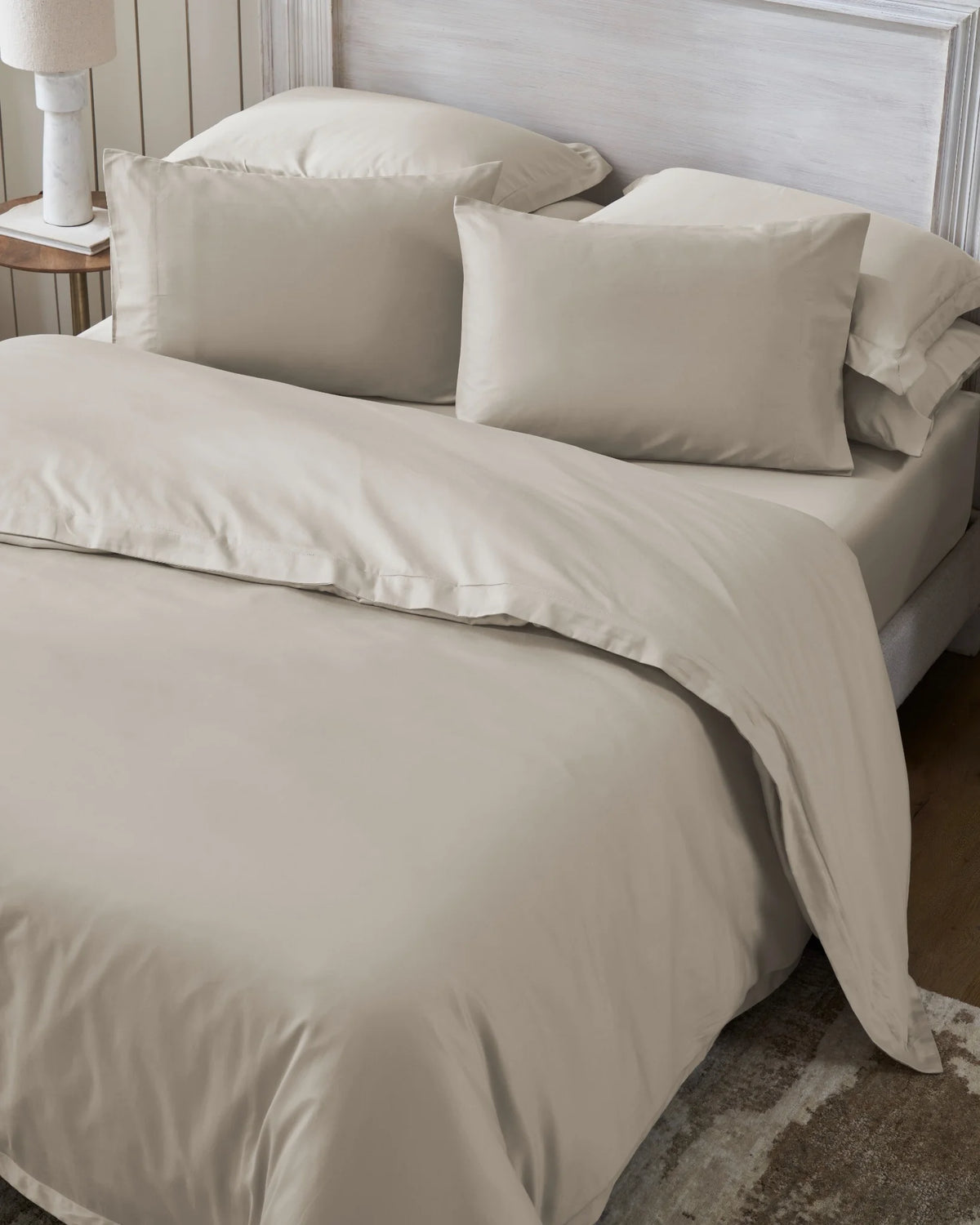 Oatmilk 600TC sateen duvet cover with flange, top view on a made bed