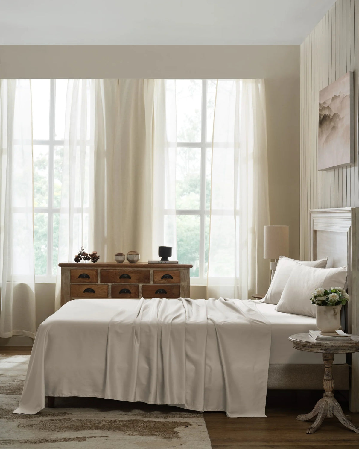 Oatmilk 600TC sateen flat sheet set with standard pillow covers, side view on a made bed