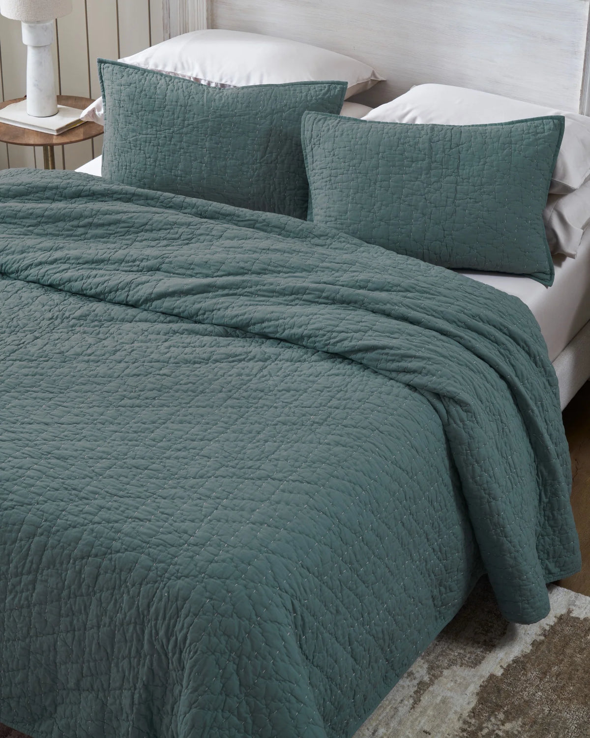 Ocean organic tri-color stitch hand quilt set with standard pillow covers, top view on a made bed
