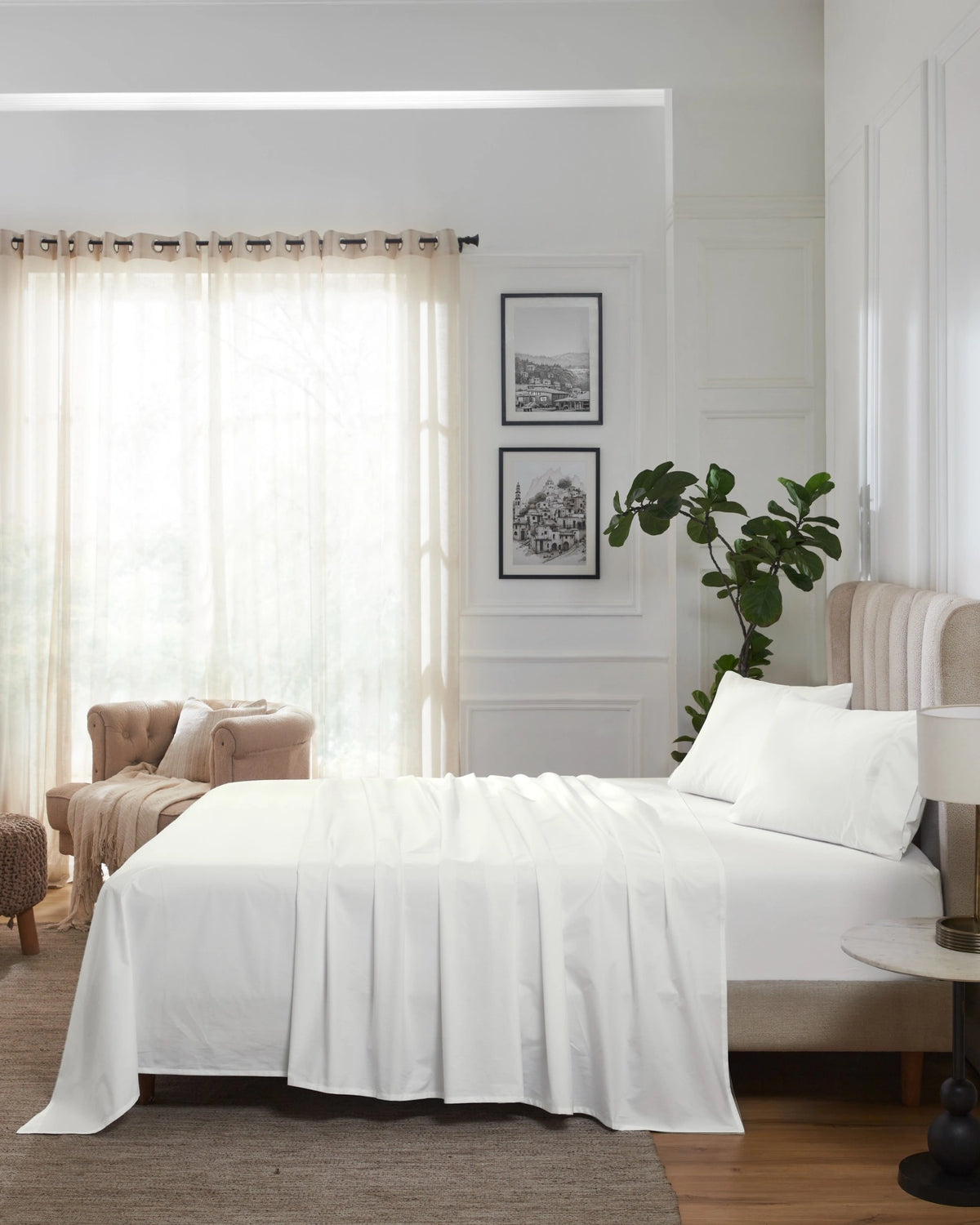 Optic White 400TC percale fitted sheet set with standard pillow covers, side view on a made bed