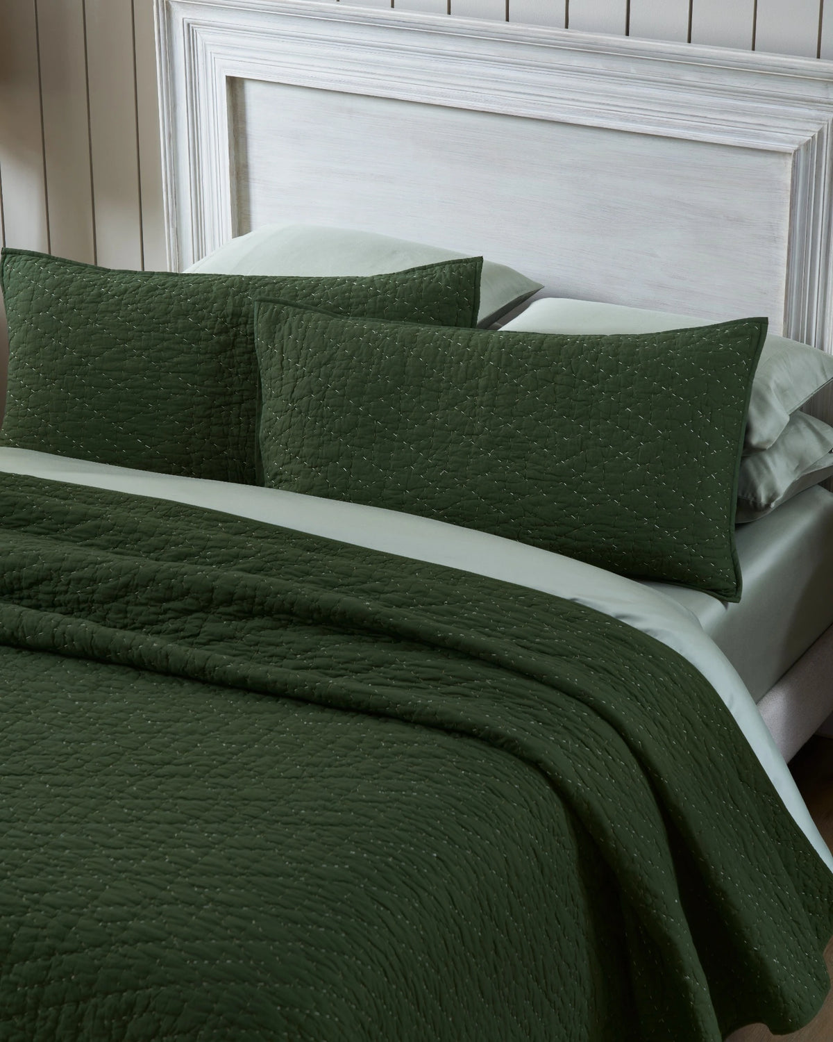 Pine organic tri-color stitch hand quilt set with king pillowcases, top view on a made bed