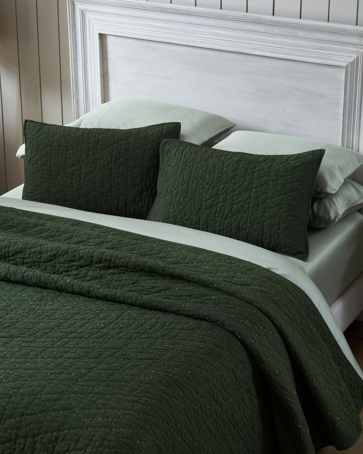Pine organic tri-color stitch hand quilt set with standard pillow covers, top view on a made bed