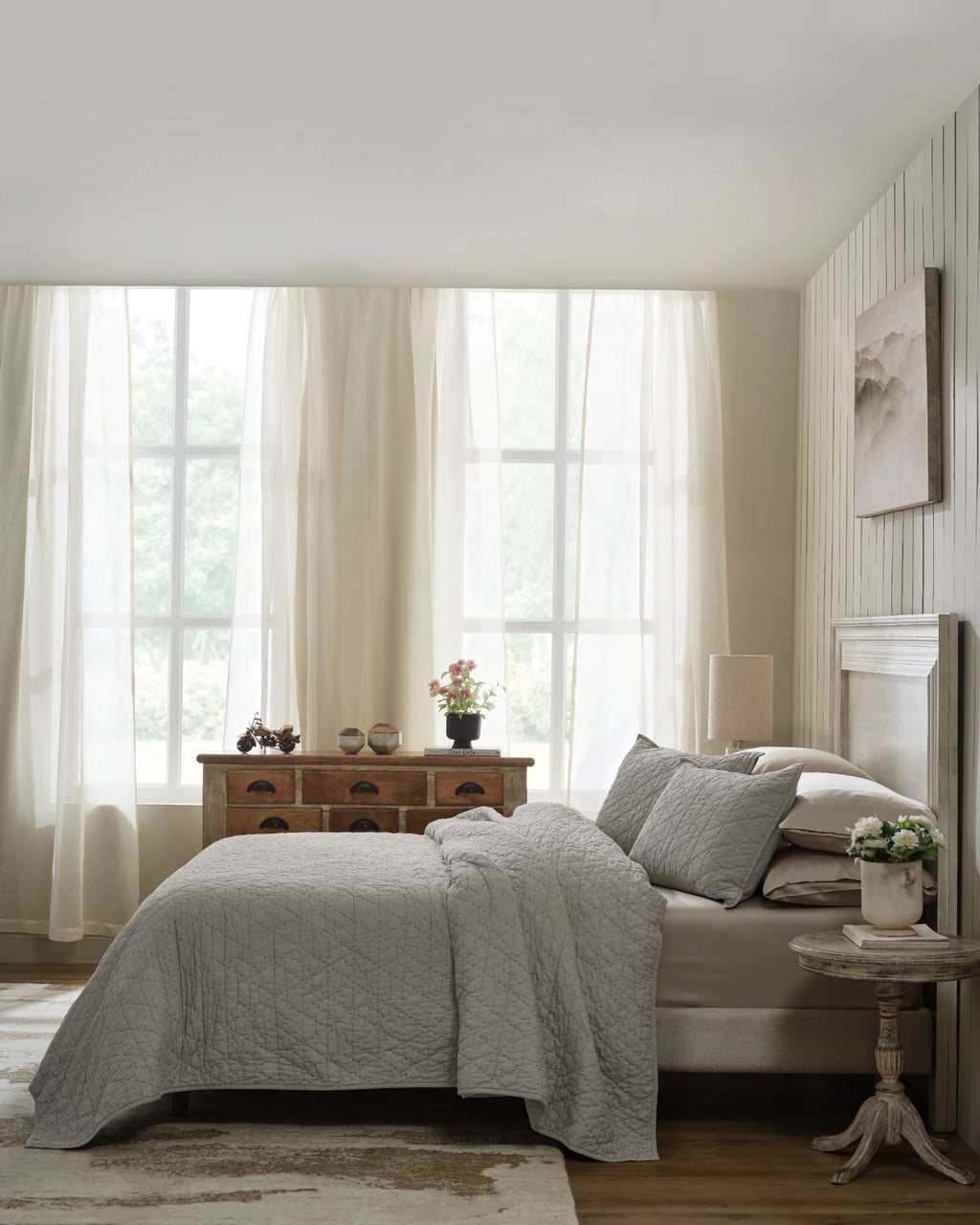 Stone organic tri-color stitch hand quilt set with standard pillow covers, side view on a made bed
