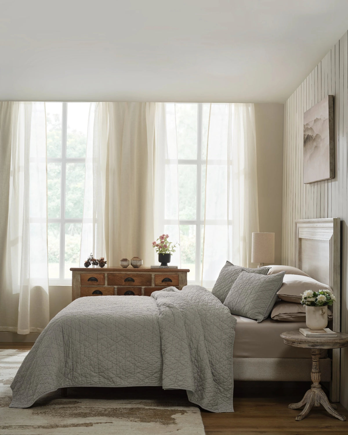 Stone organic tri-color stitch hand quilt set with standard pillow covers, side view on a made bed