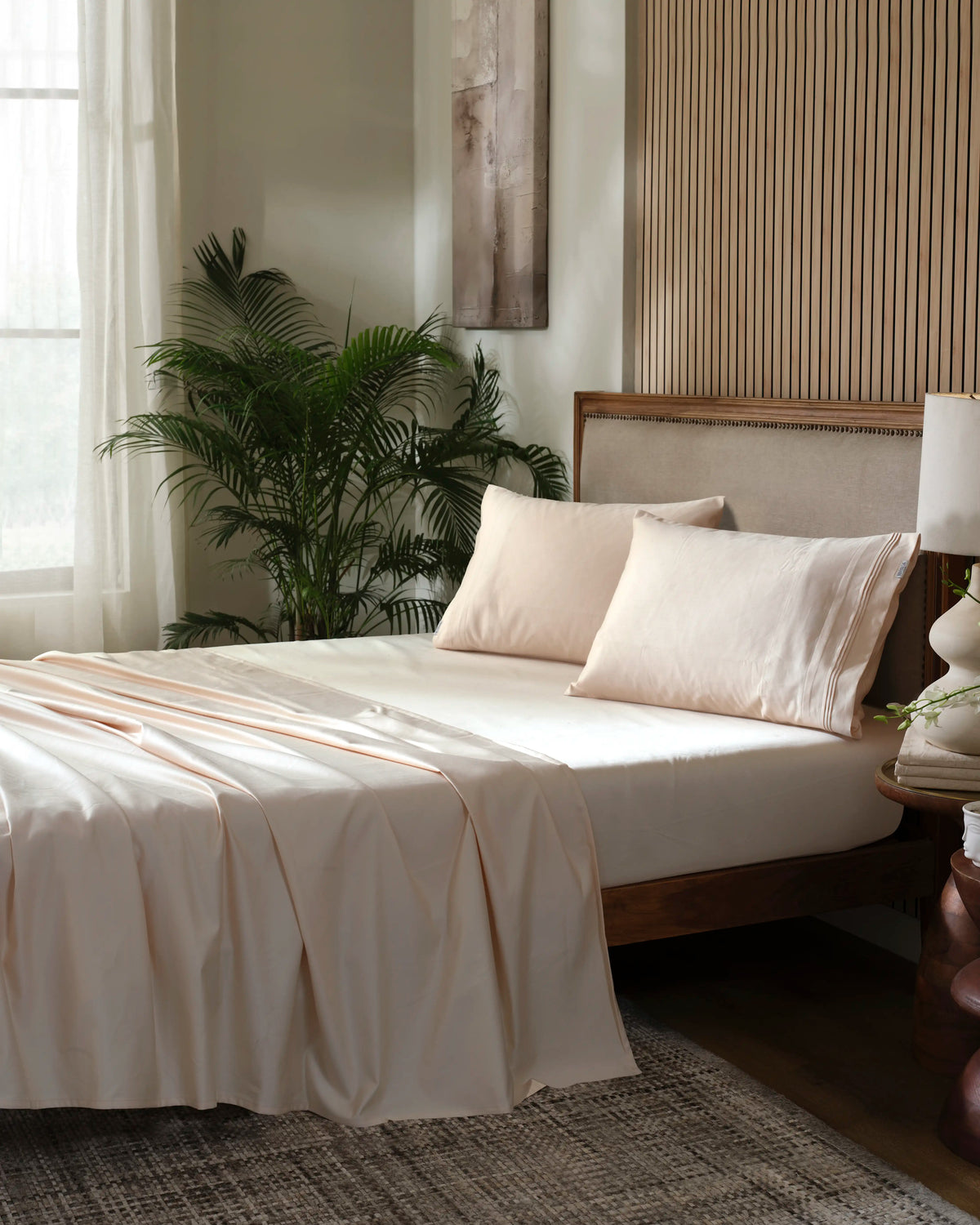 Tapioca 1000TC sateen flat and fitted sheet set with standard pillow covers, side view on a made bed