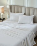 Tofu 1000TC sateen flat and fitted sheet set with standard pillow covers, top view on a made bed
